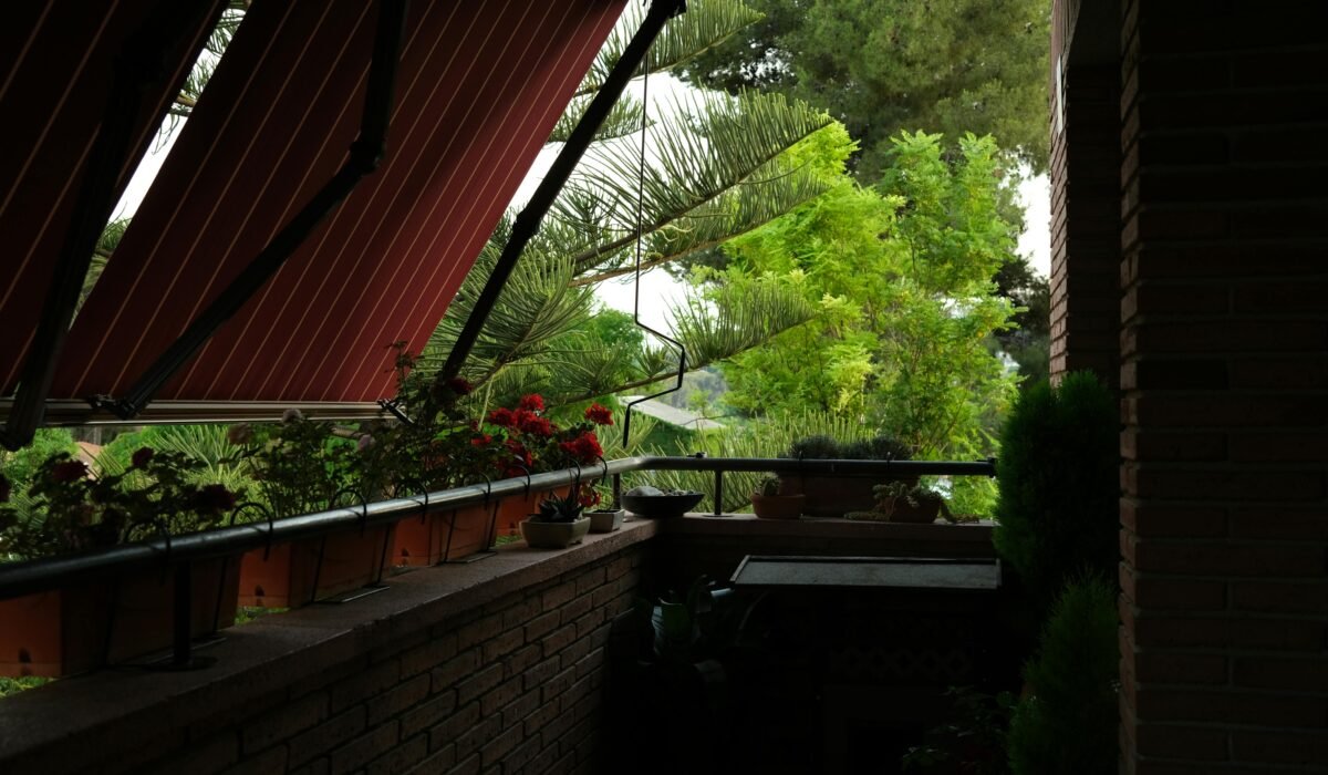 A scenic balcony view featuring potted plants and a lush canopy, perfect for relaxation. — Photo by Enric Cruz López on Pexels