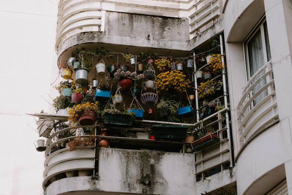 Low angle view of a balcony brimming with vibrant potted plants on a building exterior. — Photo by Mathias Reding on Pexels