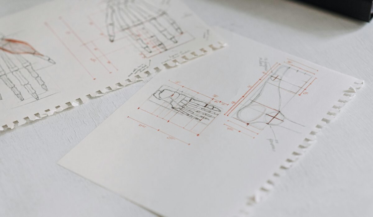 Close-up of detailed technical drawings on neatly arranged white paper sheets, highlighting design concepts. — Photo by Anete Lusina on Pexels