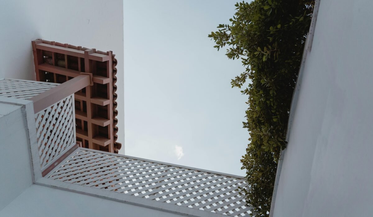 Low angle view of contemporary architecture with a white sky and lush greenery. — Photo by Tima Miroshnichenko on Pexels
