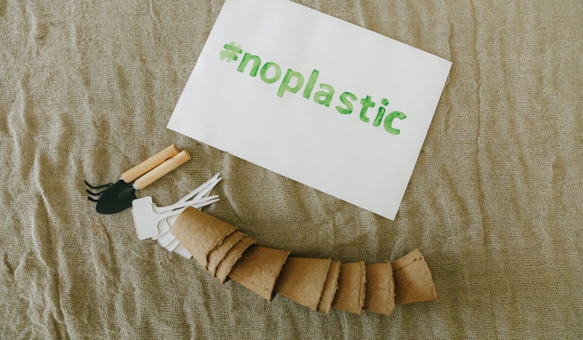 Top view of sustainable gardening tools on fabric with '#noplastic' sign. — Photo by Thirdman on Pexels